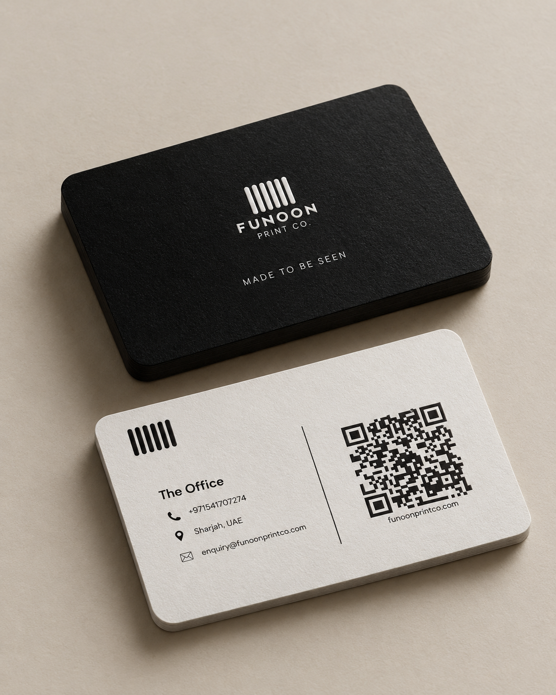 Funoon Print Co. business cards — black front with logo and white back with contact details on a stone surface